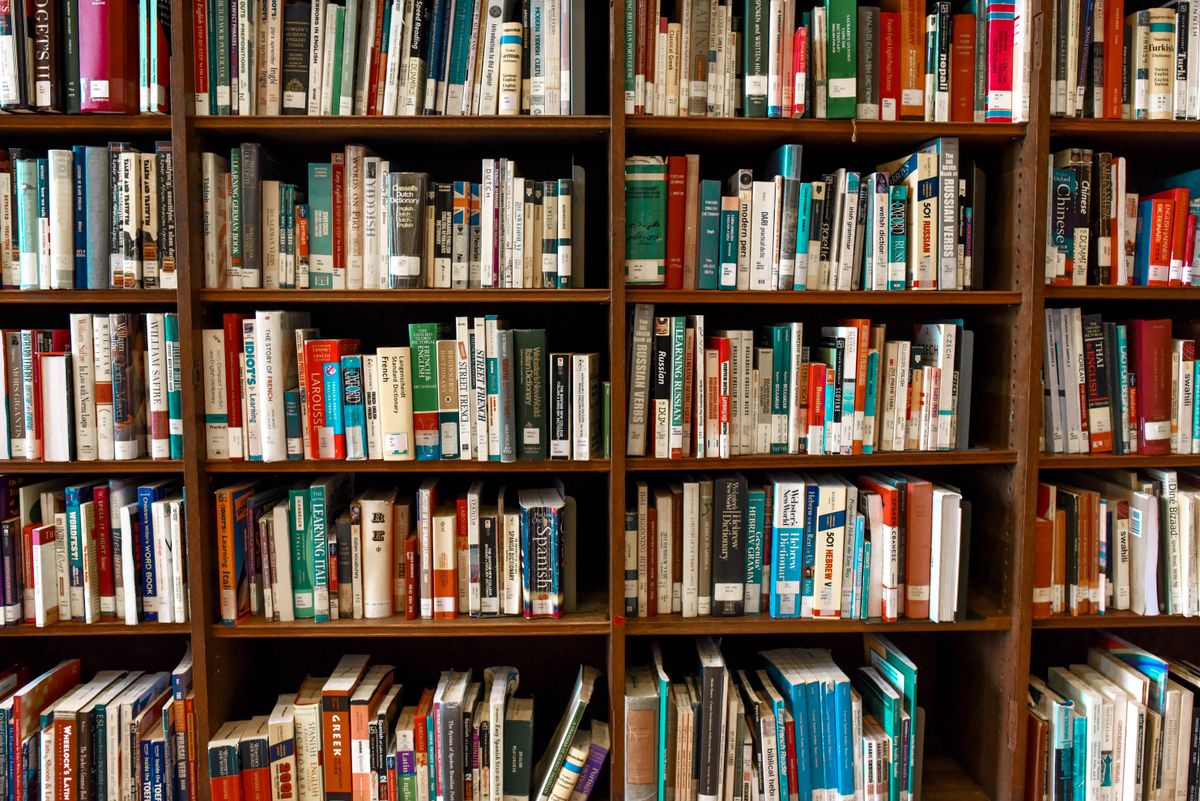 Stack of paperback books beside a reading lamp